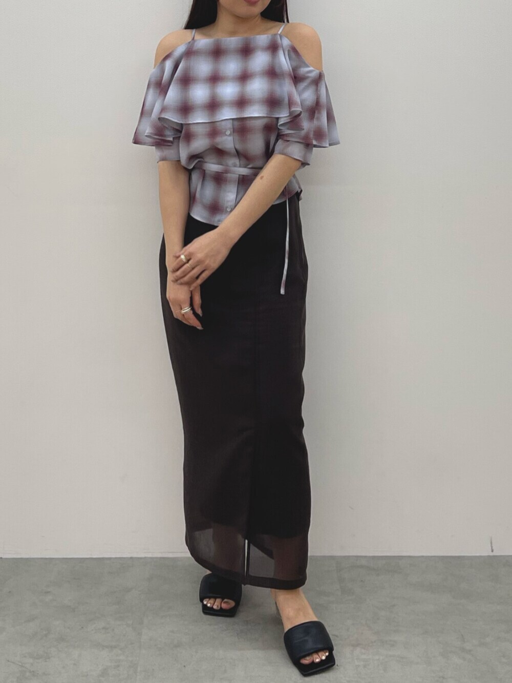 ブラウン系のスカート、ブラック系のサンダル、ピンク系のシャツ/ブラウスを着用したレディースの春コーディネートの2枚目の写真