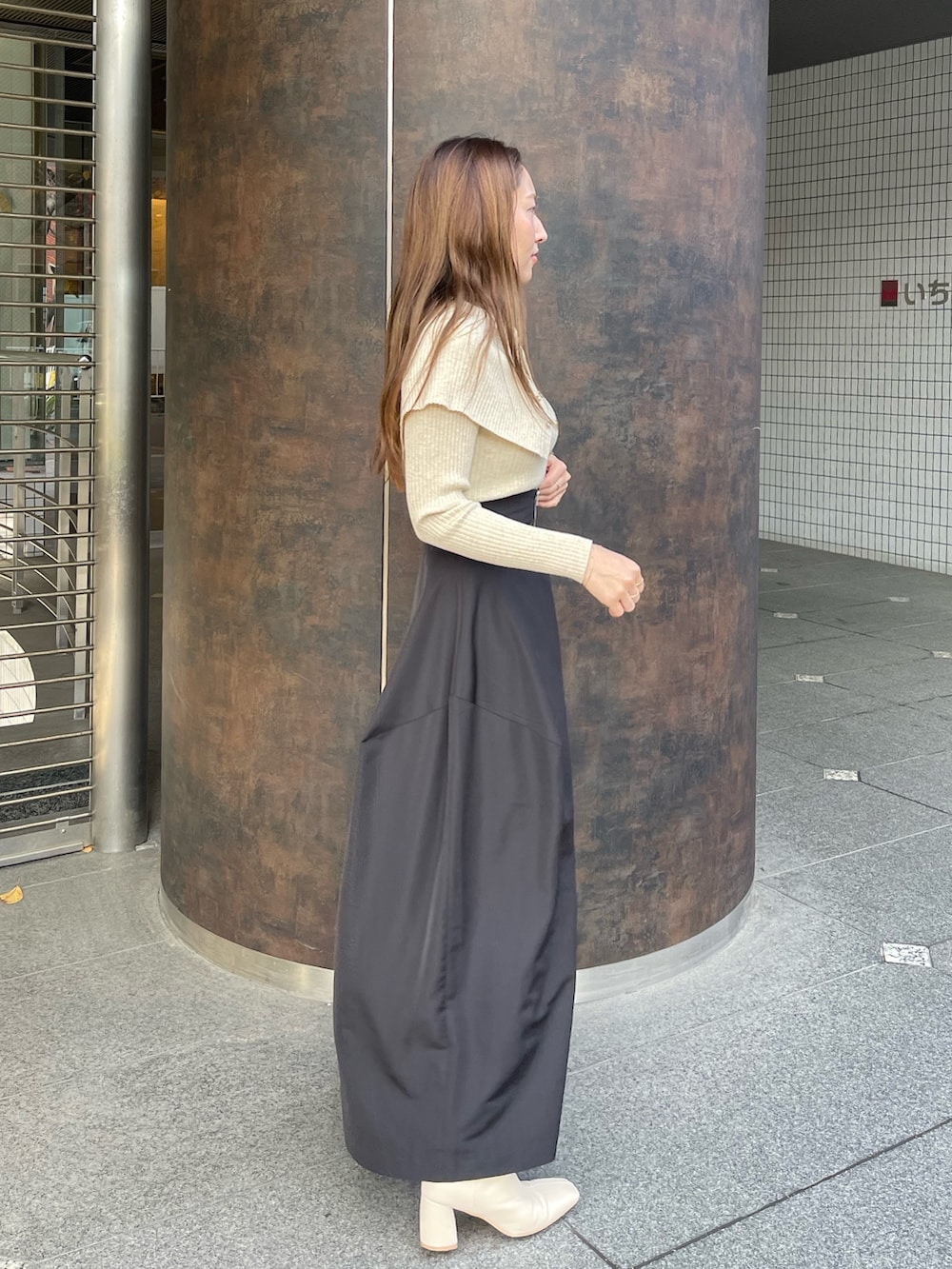 ホワイト系のブーツ、ベージュ系のニット/セーター、ブラック系のスカートを着用したレディースの冬コーディネートの2枚目の写真