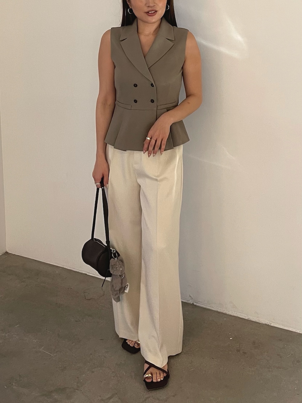 ブラウン系のサンダル、ブラウン系のベスト、ホワイト系のその他パンツを着用したレディースの春コーディネートの2枚目の写真