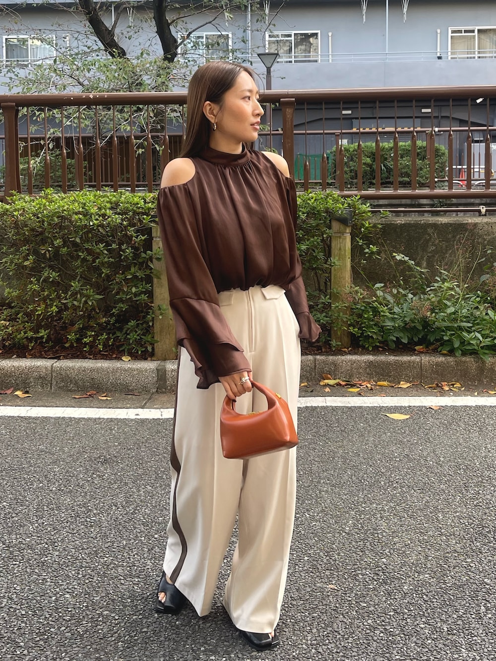 ブラック系のサンダル、ブラウン系のハンドバッグ、ホワイト系のその他パンツを着用したレディースの冬コーディネートの3枚目の写真