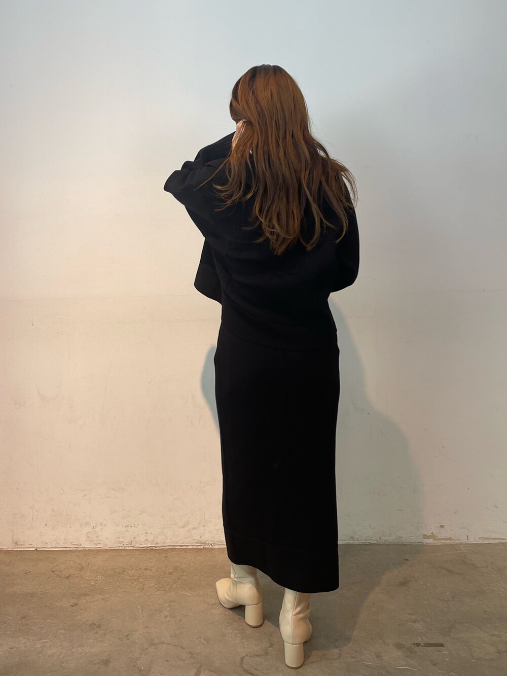 ブラック系のカーディガン/ボレロ、ブラック系のスカート、ホワイト系のブーツを着用したレディースの夏コーディネートの5枚目の写真