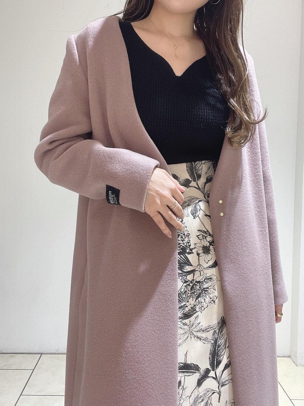 ベージュ系のスカート、ブラック系のニット/セーターを着用したレディースの秋コーディネートの9枚目の写真