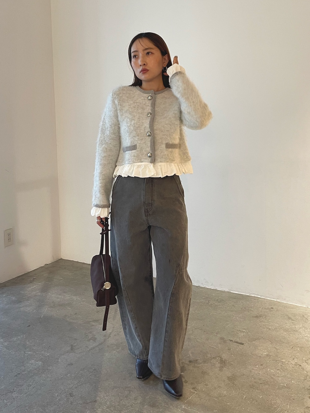 ブラウン系のハンドバッグ、グレー系のデニムパンツ、グレー系のノーカラージャケットを着用したレディースの秋コーディネートの3枚目の写真