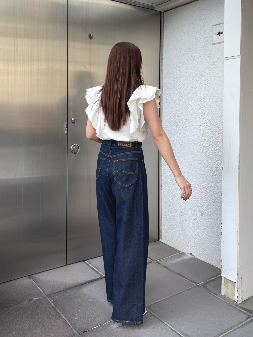 ホワイト系のサンダル、ホワイト系のシャツ/ブラウス、ブルー系のデニムパンツを着用したレディースの春コーディネートの6枚目の写真