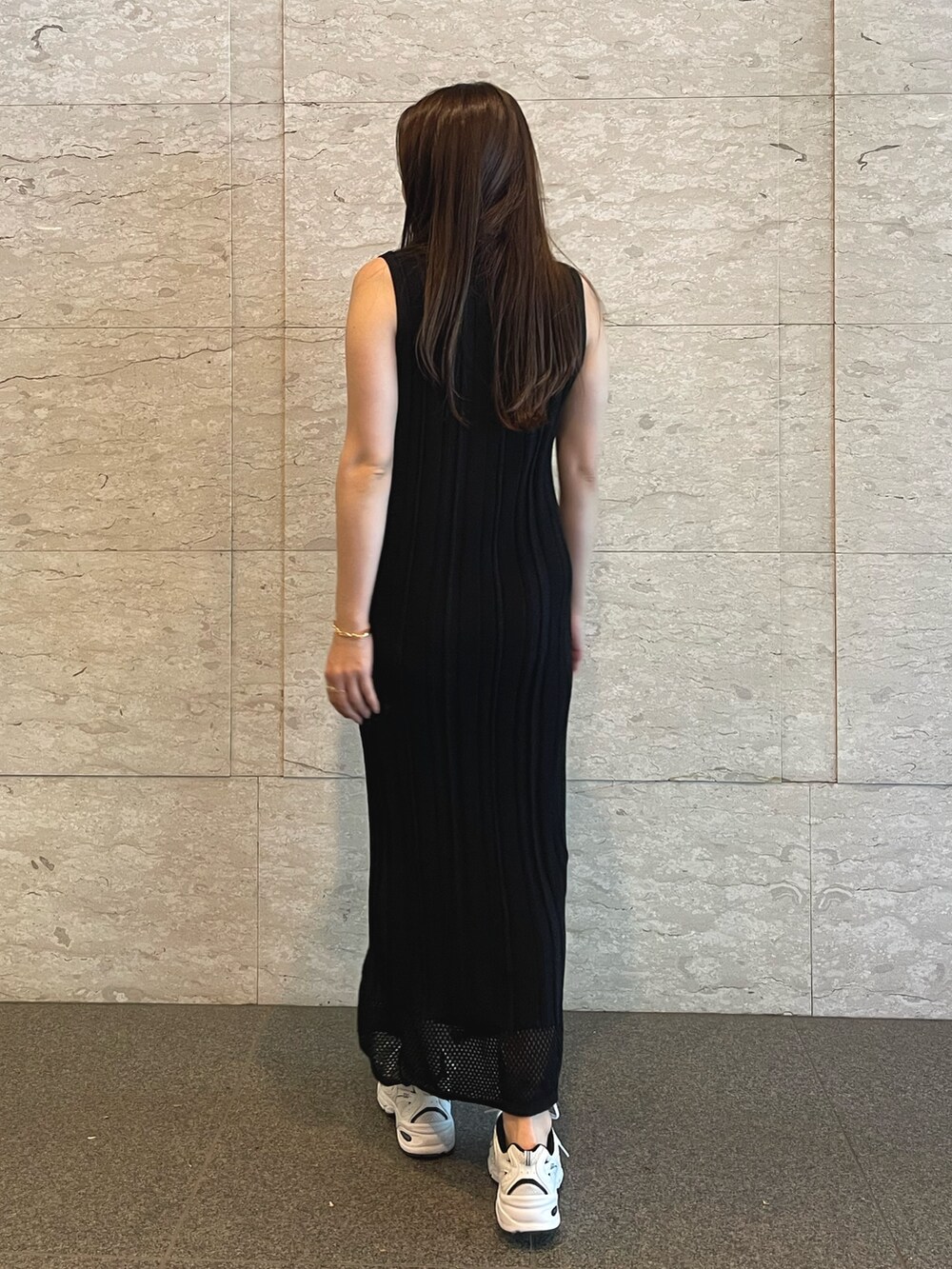 ブラック系のワンピース、ゴールド系のブレスレットを着用したレディースの夏コーディネートの5枚目の写真