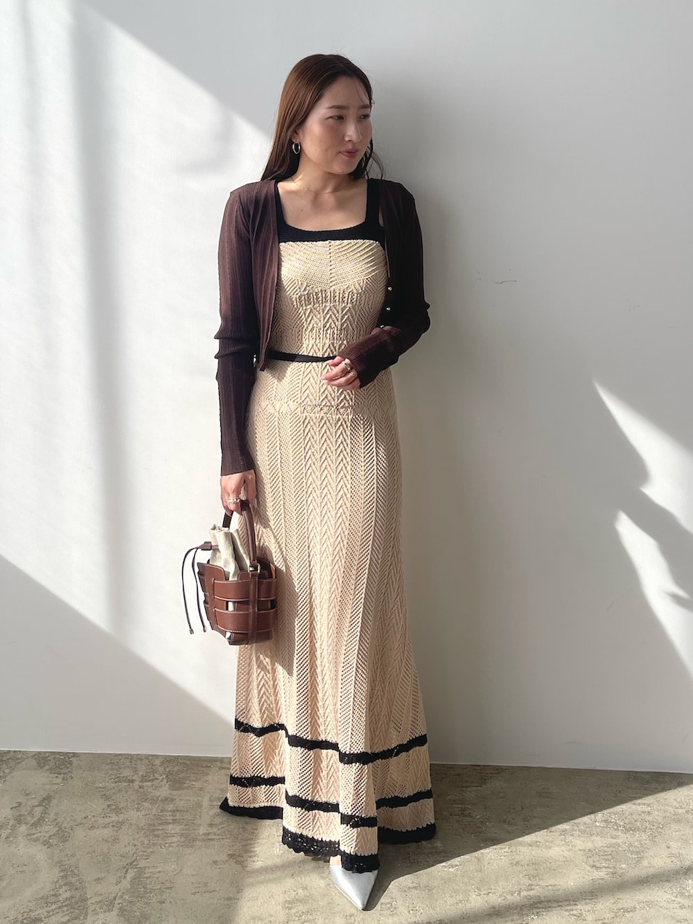 ベージュ系のワンピース、ブラウン系のカーディガン/ボレロ、シルバー系のパンプスを着用したレディースの春コーディネートの5枚目の写真