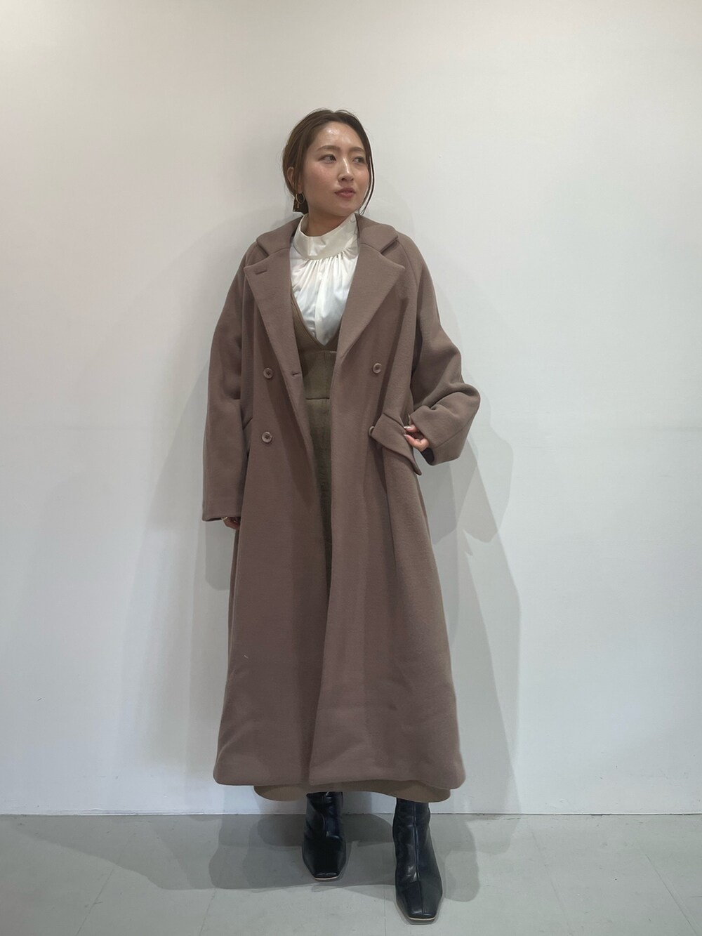 ベージュ系のジャンパースカート、ホワイト系のシャツ/ブラウス、ブラック系のブーツを着用したレディースの秋コーディネートの2枚目の写真