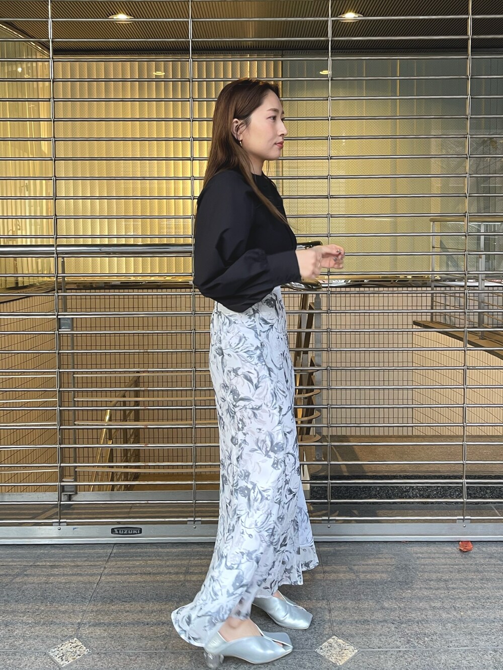 グレー系のスカート、シルバー系のパンプス、ブラック系のニット/セーターを着用したレディースの冬コーディネートの3枚目の写真