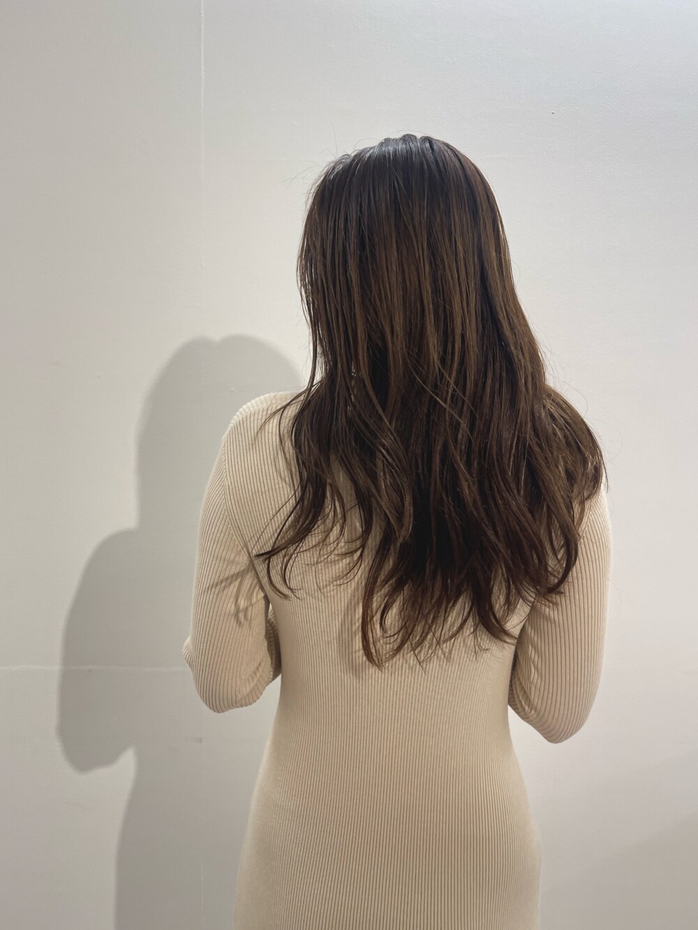 ホワイト系のワンピース、ホワイト系のパンプス、ゴールド系のイヤリングを着用したレディースの冬コーディネートの9枚目の写真