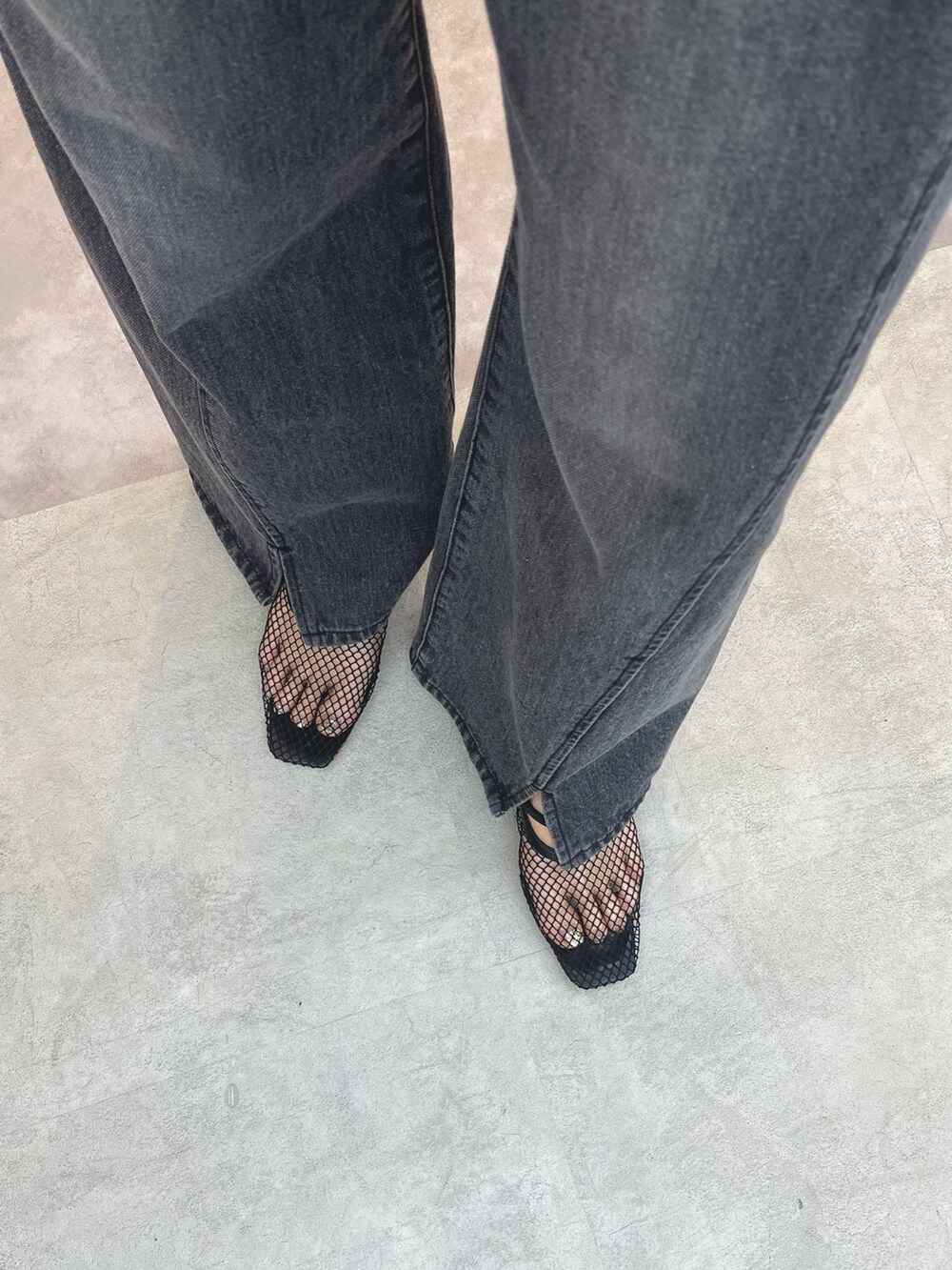 ブラック系のデニムパンツ、ホワイト系のサンダル、グレー系のTシャツ/カットソーを着用したレディースの春コーディネートの5枚目の写真