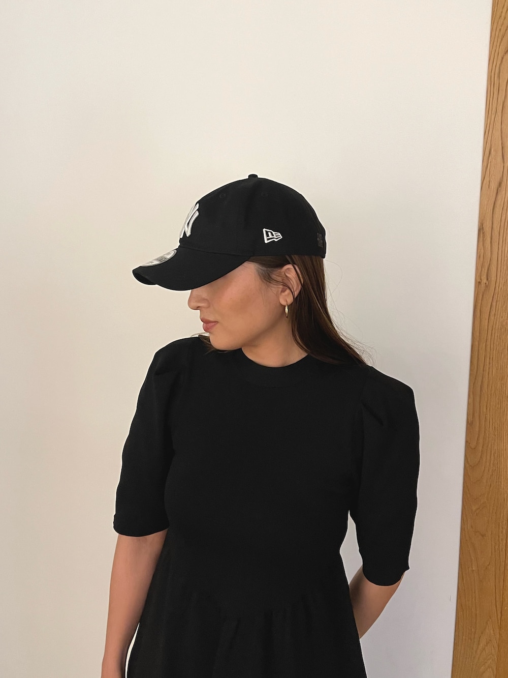 ブラック系のワンピース、ブラック系のキャップを着用したレディースの冬コーディネートの8枚目の写真