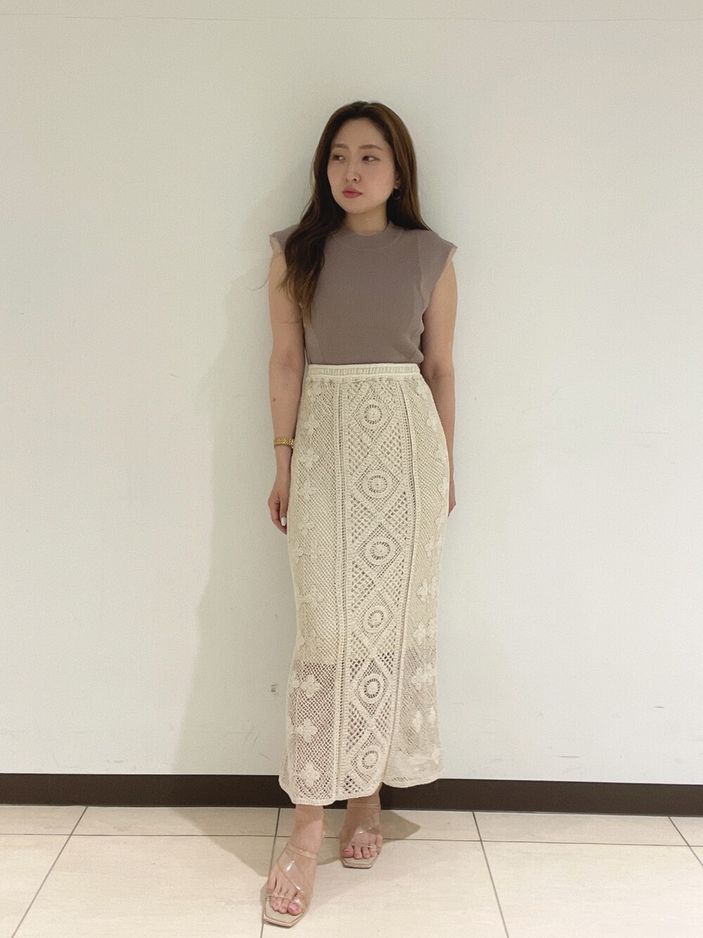 ホワイト系のスカート、ベージュ系のニット/セーターを着用したレディースの夏コーディネートの3枚目の写真