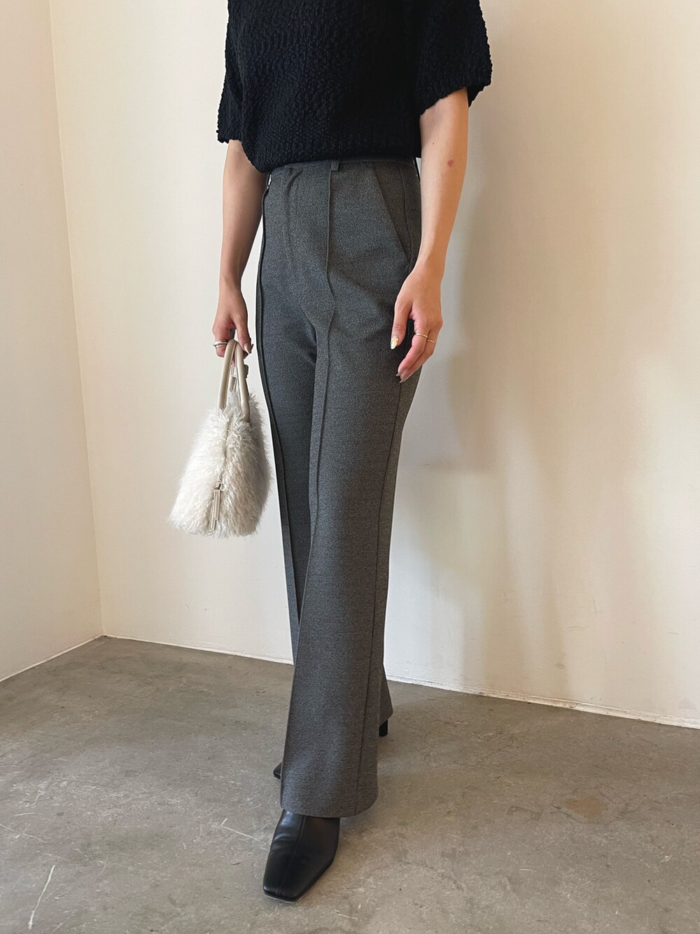 ホワイト系のボストンバッグ、ブラック系のブーツ、ブラック系のニット/セーターを着用したレディースの夏コーディネートの9枚目の写真