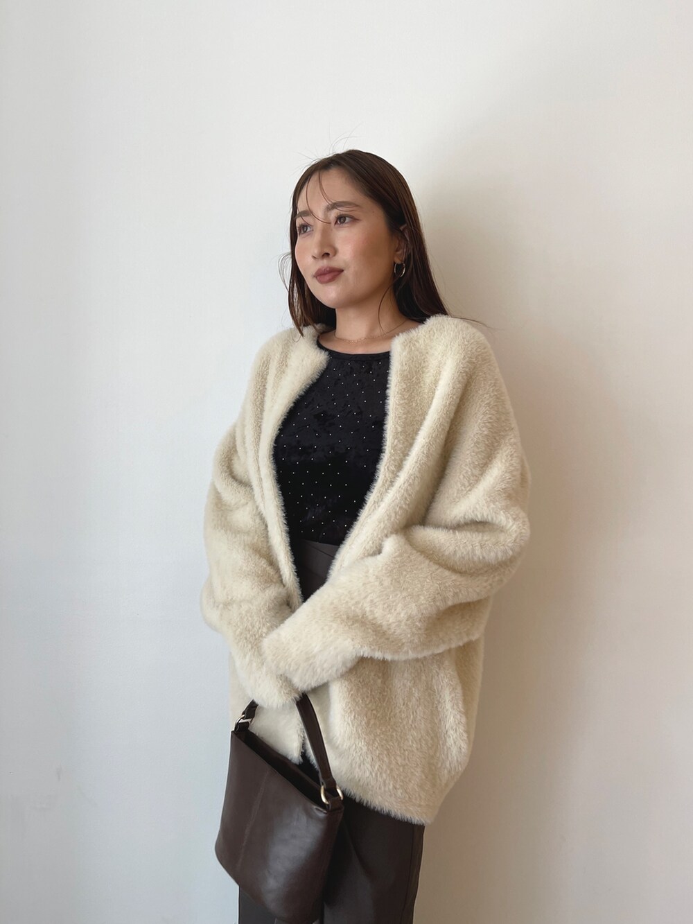 ブラック系のTシャツ/カットソー、ブラウン系のハンドバッグ、ブラウン系のスカートを着用したレディースの秋コーディネートの7枚目の写真