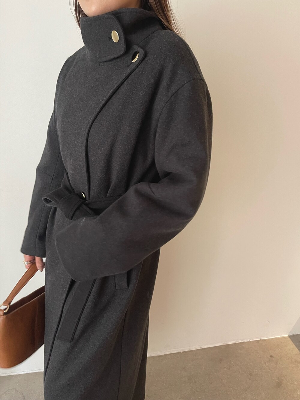 ブラウン系のスカート、イエロー系のハンドバッグ、グレー系のチェスターコートを着用したレディースの秋コーディネートの8枚目の写真