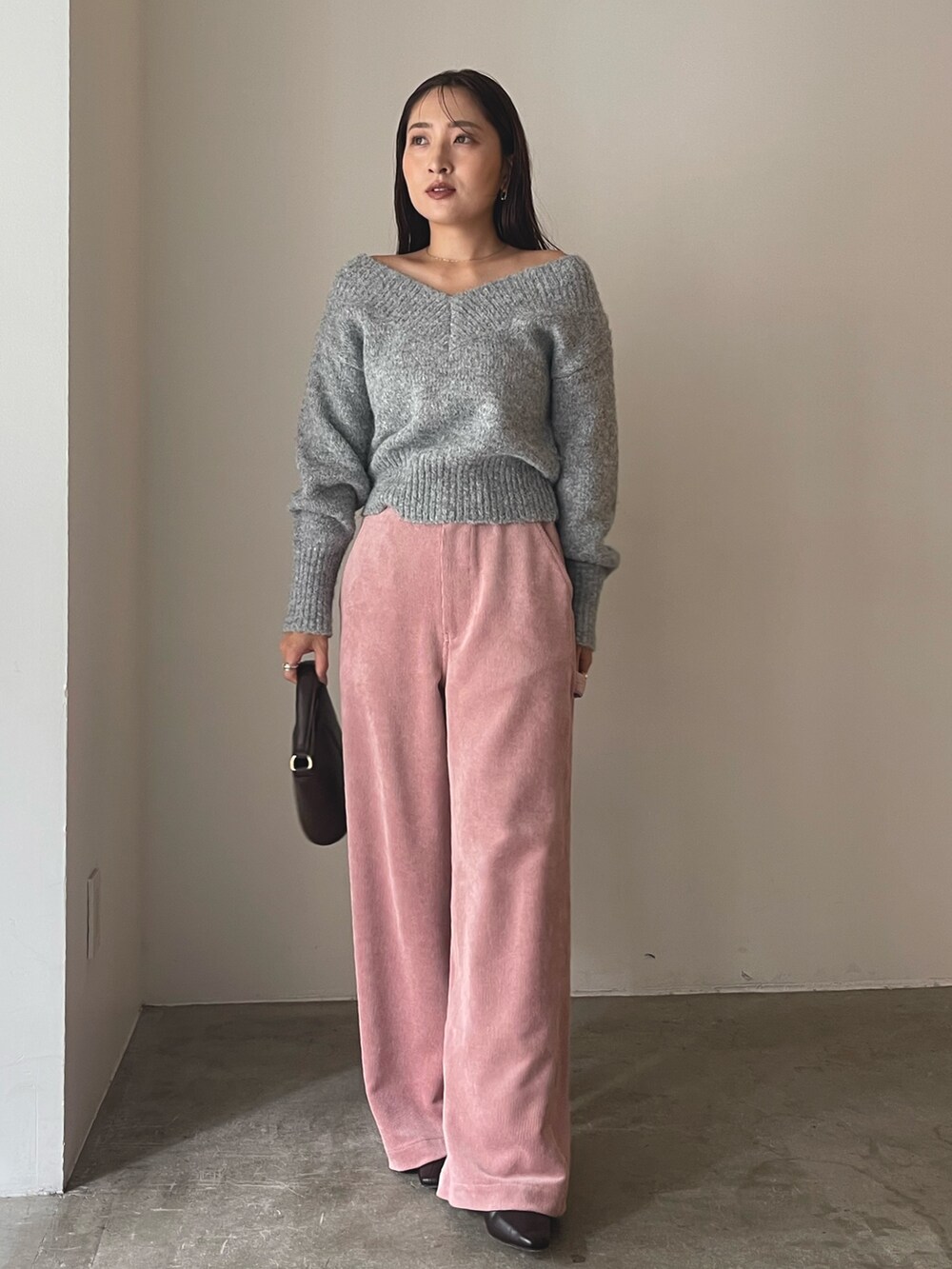 ブラウン系のハンドバッグ、ブラウン系のブーツ、ピンク系のその他パンツを着用したレディースの秋コーディネートの4枚目の写真