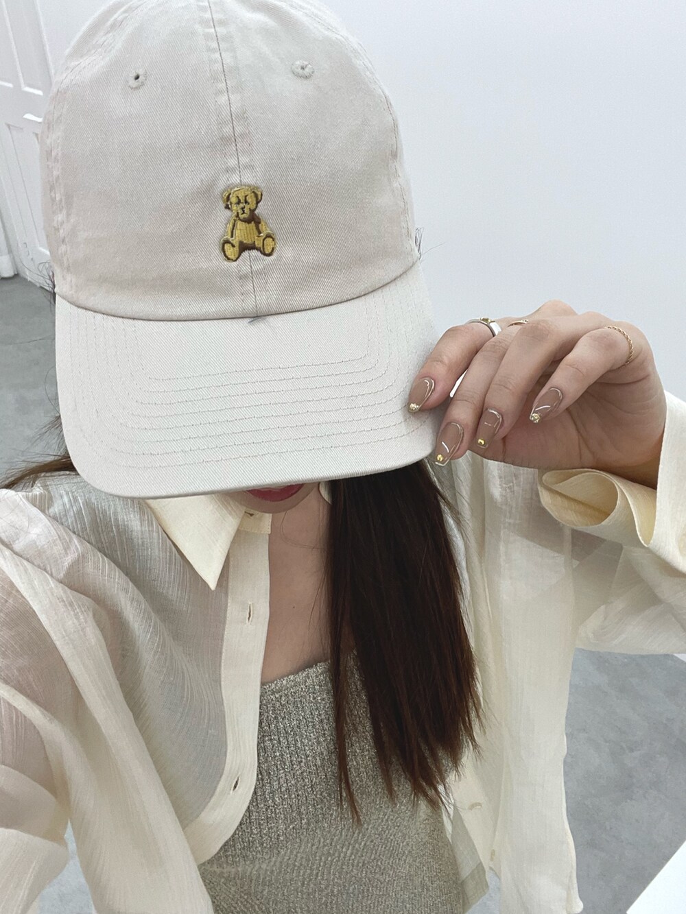 ベージュ系のワンピース、ホワイト系のスニーカー、ホワイト系のシャツ/ブラウスを着用したレディースの春コーディネートの10枚目の写真