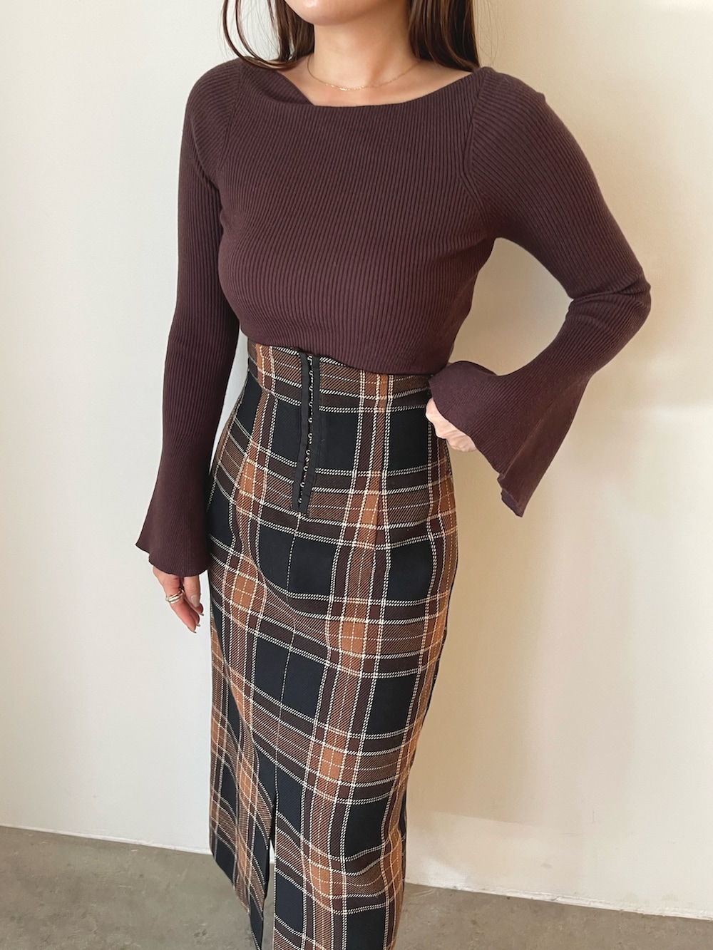 ブラック系のブーツ、ブラウン系のスカート、ブラウン系のニット/セーターを着用したレディースの秋コーディネートの6枚目の写真