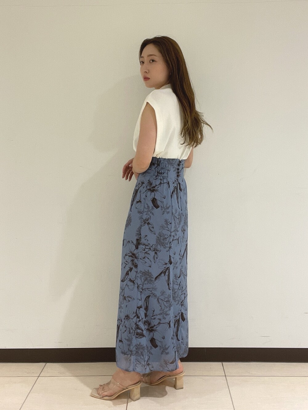 ブルー系のスカート、ホワイト系のニット/セーターを着用したレディースの夏コーディネートの6枚目の写真