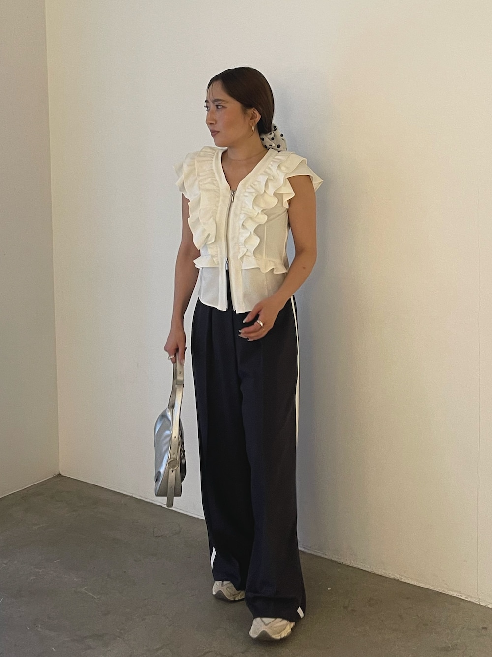 シルバー系のハンドバッグ、ホワイト系のシャツ/ブラウス、グレー系のその他パンツを着用したレディースの春コーディネートの3枚目の写真