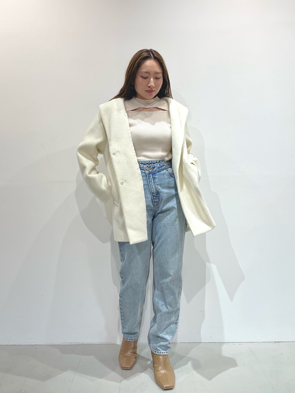 ホワイト系のニット/セーター、ベージュ系のブーツ、ホワイト系のその他アウターを着用したレディースの秋コーディネートの4枚目の写真