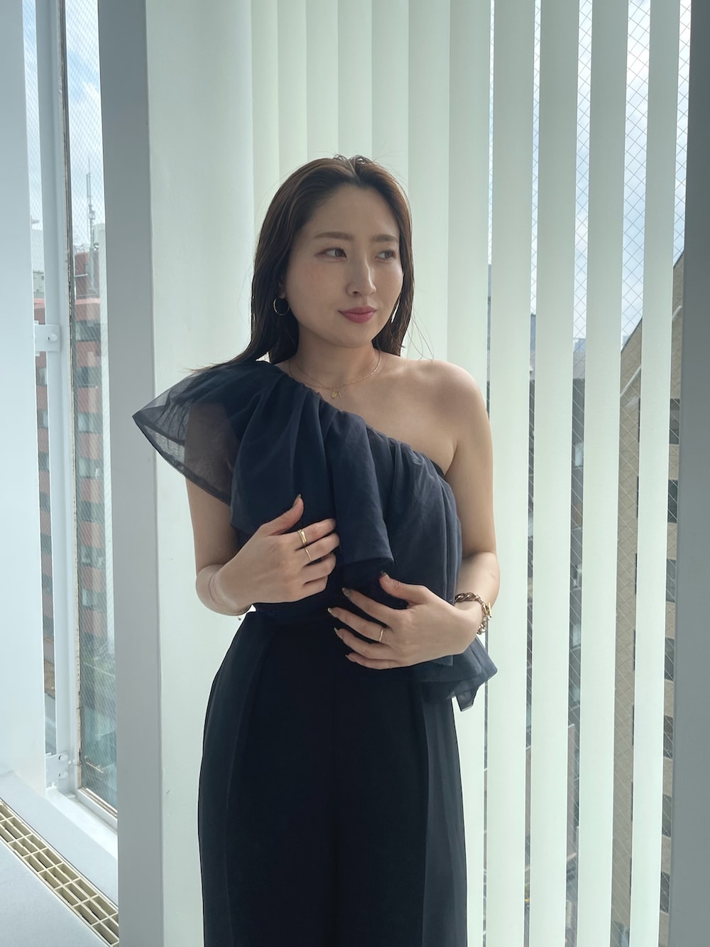 ゴールド系のパンプス、ブラック系のパンツドレスを着用したレディースの夏コーディネートの7枚目の写真
