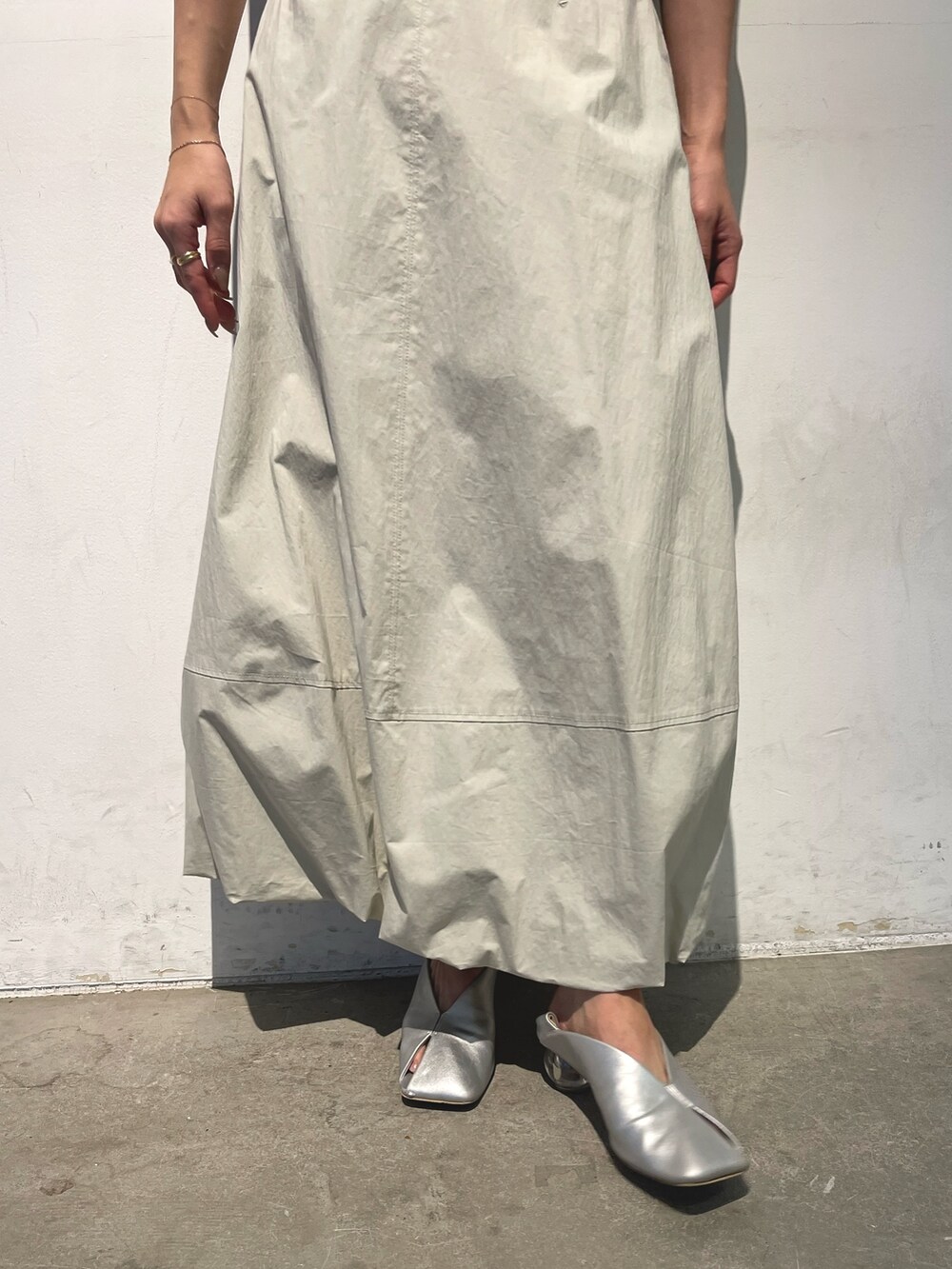 シルバー系のパンプス、ブラック系のニット/セーター、ホワイト系のスカートを着用したレディースの春コーディネートの8枚目の写真