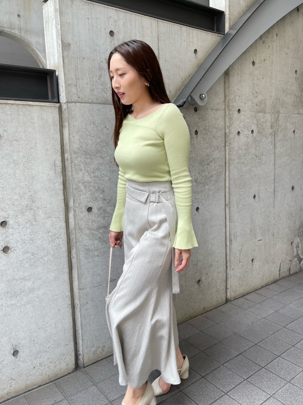 ホワイト系のショルダーバッグ、ホワイト系のパンプス、グレー系のスカートを着用したレディースの秋コーディネートの7枚目の写真