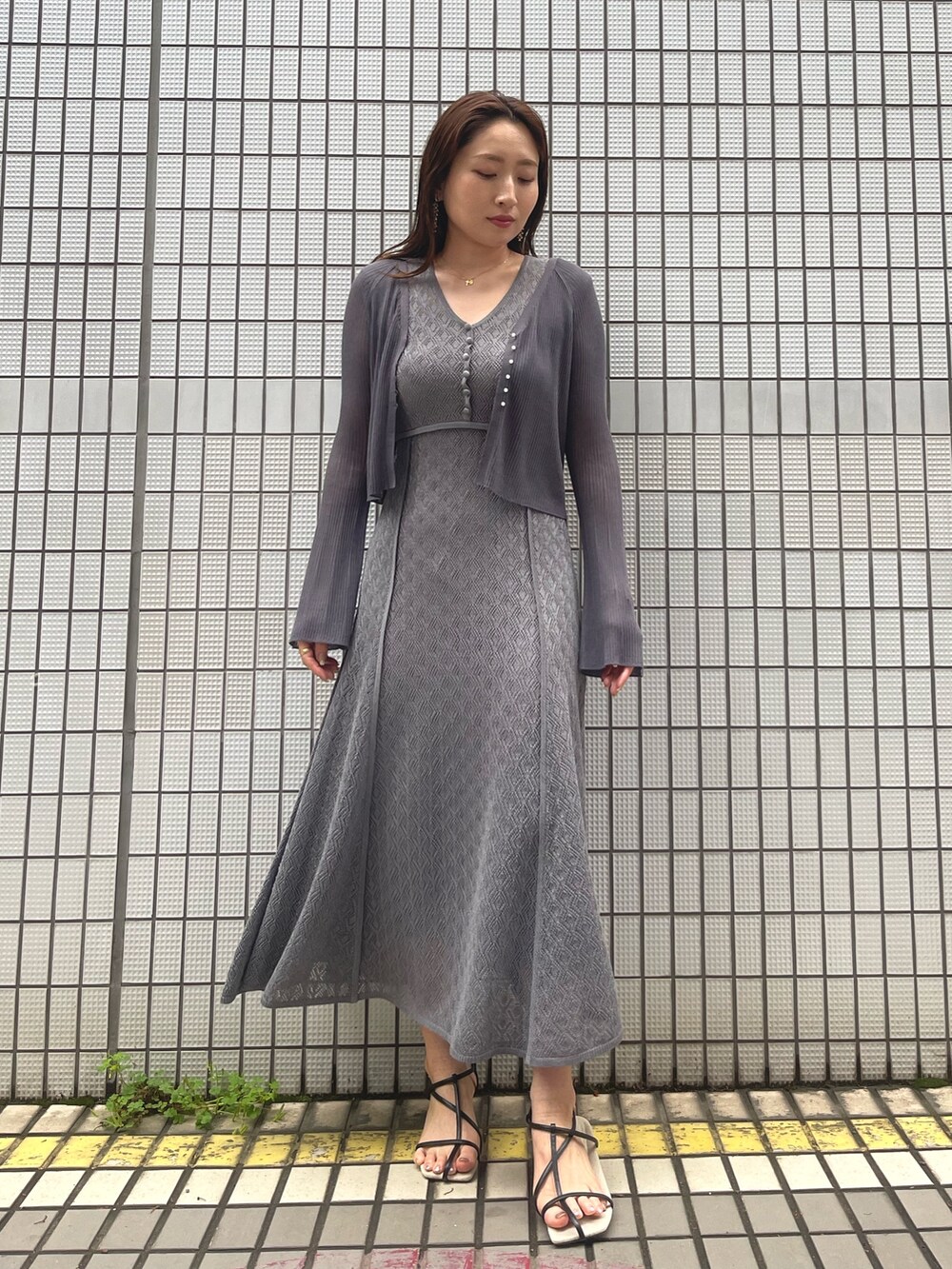 グレー系のワンピース、ブラック系のサンダル、グレー系のカーディガン/ボレロを着用したレディースの春コーディネートの4枚目の写真