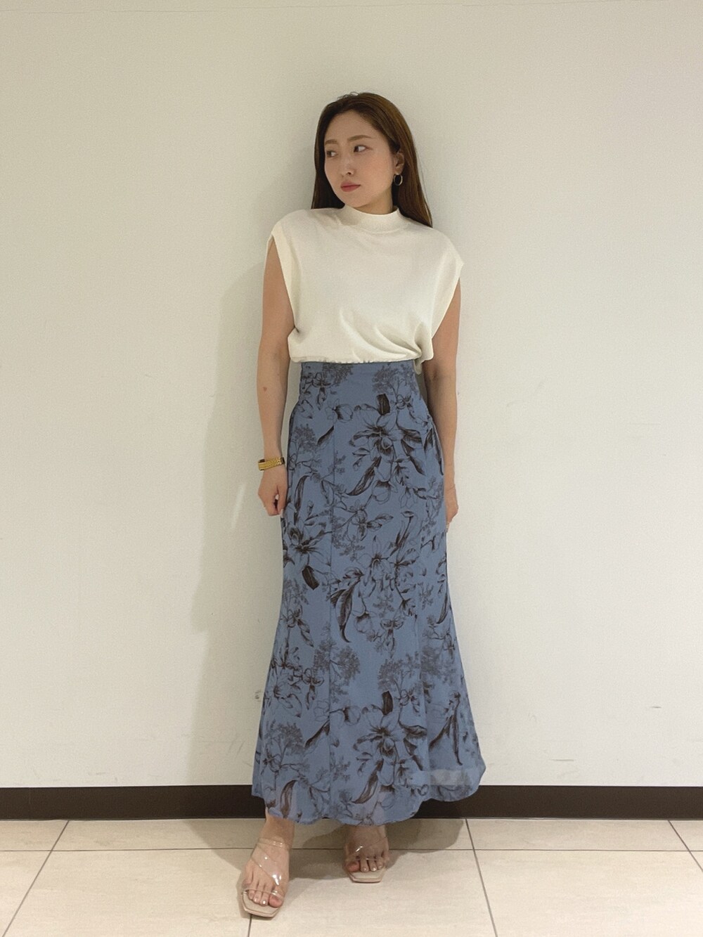 ブルー系のスカート、ホワイト系のニット/セーターを着用したレディースの夏コーディネートの9枚目の写真