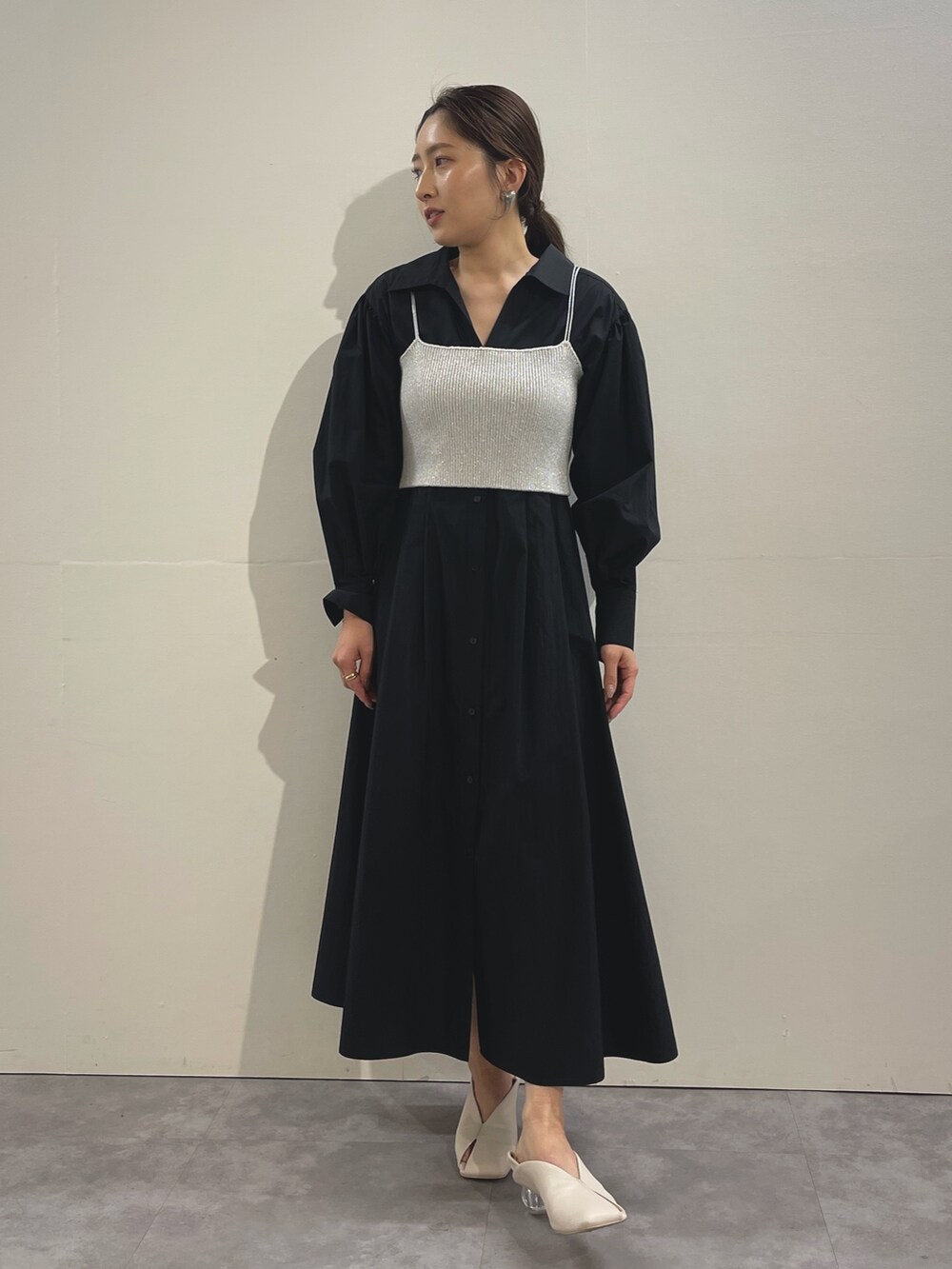 ホワイト系のパンプス、ブラック系のシャツワンピース、シルバー系のイヤリングを着用したレディースの冬コーディネートの3枚目の写真