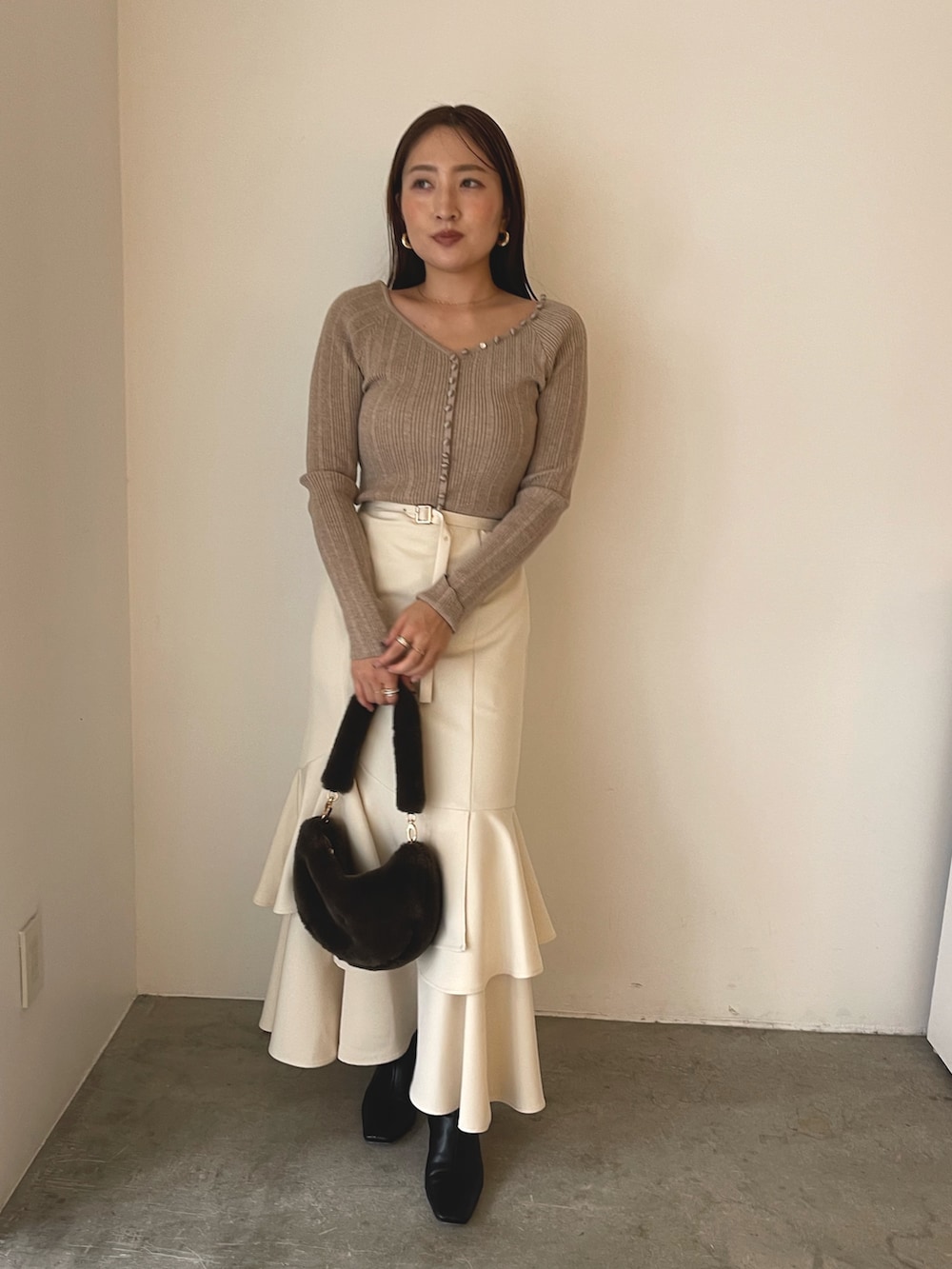 ブラウン系のショルダーバッグ、ブラック系のブーツ、ベージュ系のワンピースを着用したレディースの冬コーディネートの4枚目の写真