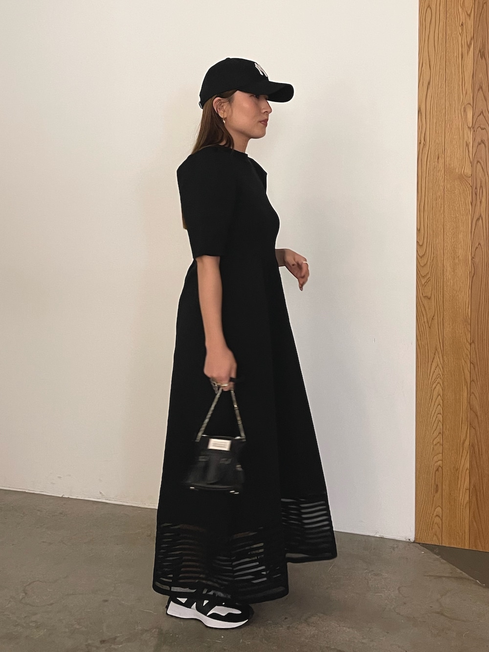 ブラック系のワンピース、ブラック系のキャップを着用したレディースの冬コーディネートの7枚目の写真