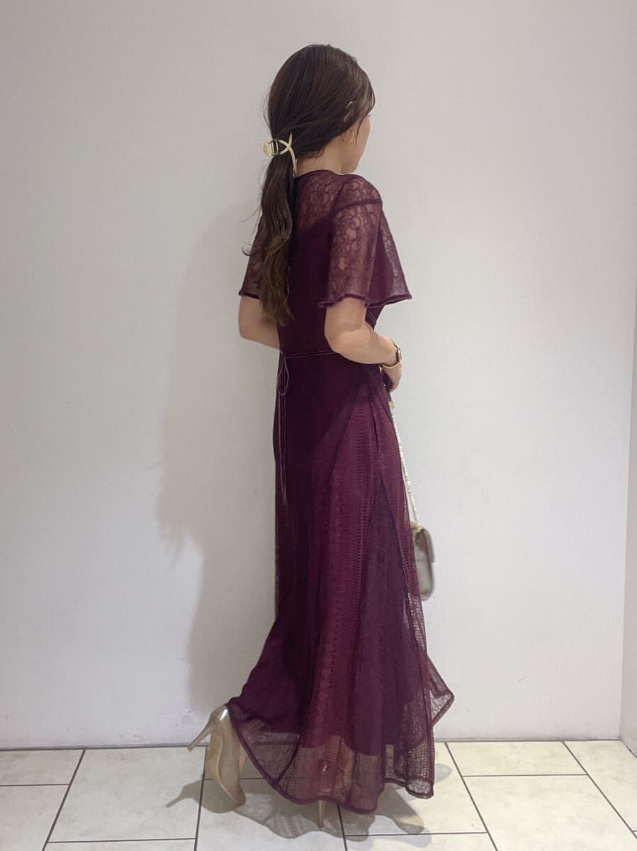 ゴールド系のクラッチバッグ、レッド系のドレス、ゴールド系のパンプスを着用したレディースの夏コーディネートの5枚目の写真