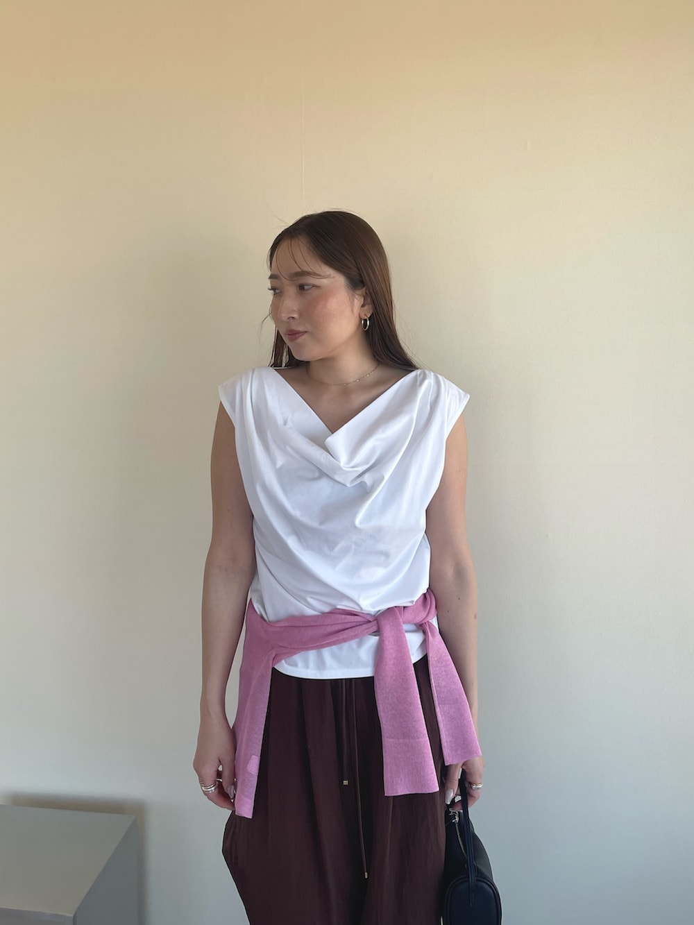 ホワイト系のTシャツ/カットソー、ピンク系のカーディガン/ボレロ、ブラック系のパンプスを着用したレディースの春コーディネートの5枚目の写真