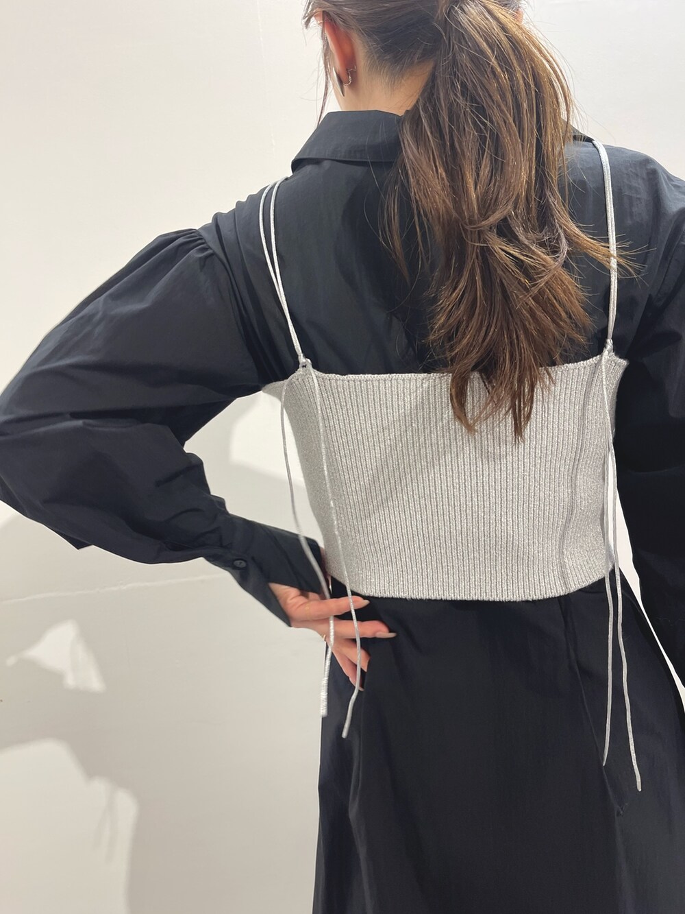 ホワイト系のパンプス、ブラック系のシャツワンピース、シルバー系のイヤリングを着用したレディースの冬コーディネートの8枚目の写真