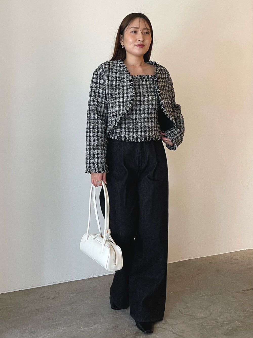 ホワイト系のショルダーバッグ、ブラック系のキャミソール、ブラック系のテーラードジャケットを着用したレディースの秋コーディネートの3枚目の写真