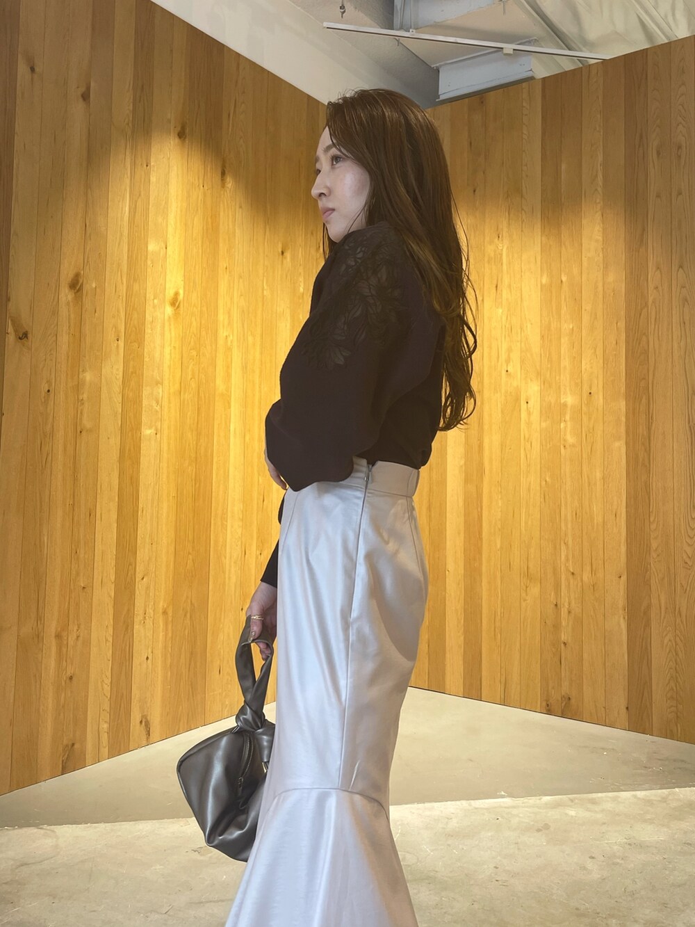 グレー系のニット/セーター、その他のハンドバッグ、ブラウン系のスカートを着用したレディースの秋コーディネートの7枚目の写真