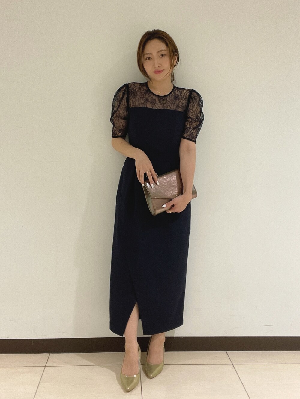 ブルー系のドレス、ゴールド系のハンドバッグ、ゴールド系のパンプスを着用したレディースの夏コーディネートの3枚目の写真