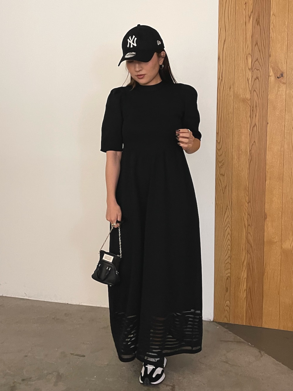 ブラック系のワンピース、ブラック系のキャップを着用したレディースの冬コーディネートの4枚目の写真