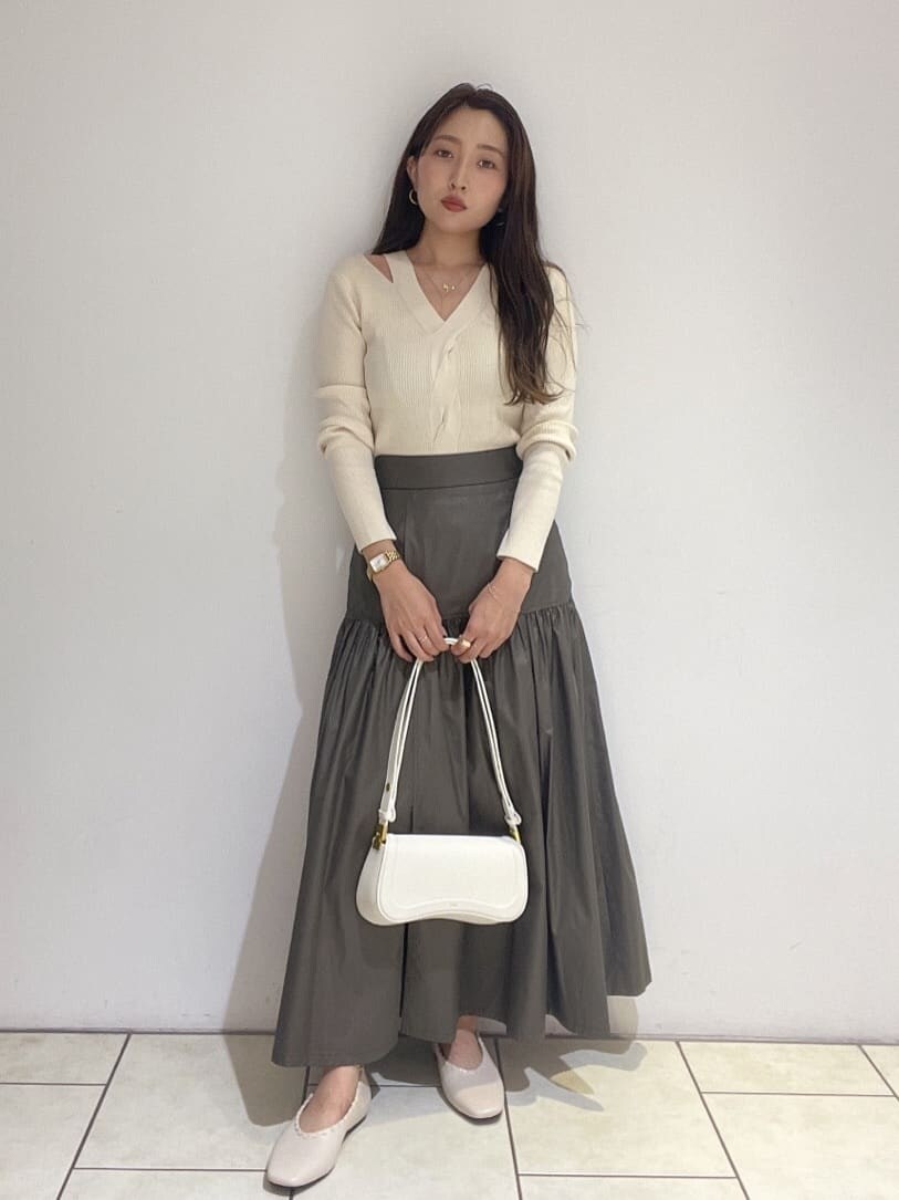 ベージュ系のスカート、ホワイト系のパンプス、ホワイト系のニット/セーターを着用したレディースの夏コーディネートの2枚目の写真