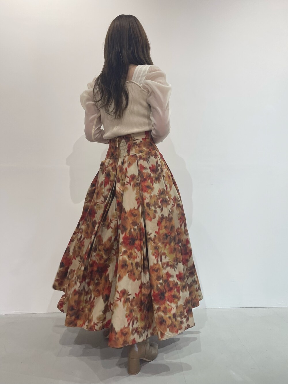 ベージュ系のブーツ、オレンジ系のスカート、ホワイト系のニット/セーターを着用したレディースの秋コーディネートの5枚目の写真