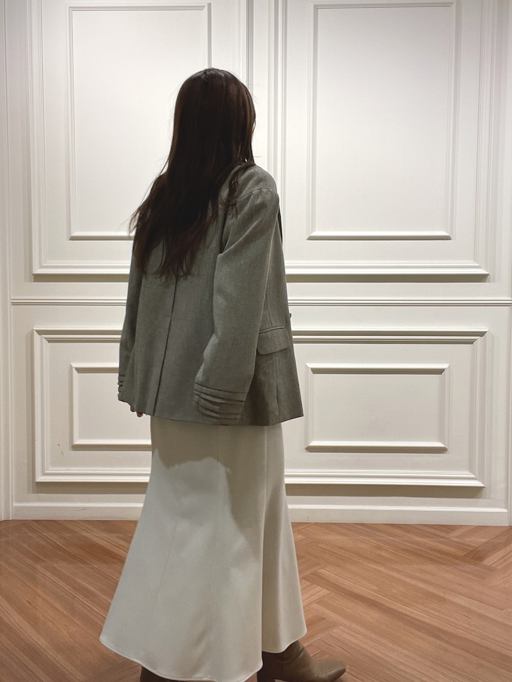 ホワイト系のスカート、ベージュ系のテーラードジャケット、ブラック系のニット/セーターを着用したレディースの秋コーディネートの4枚目の写真