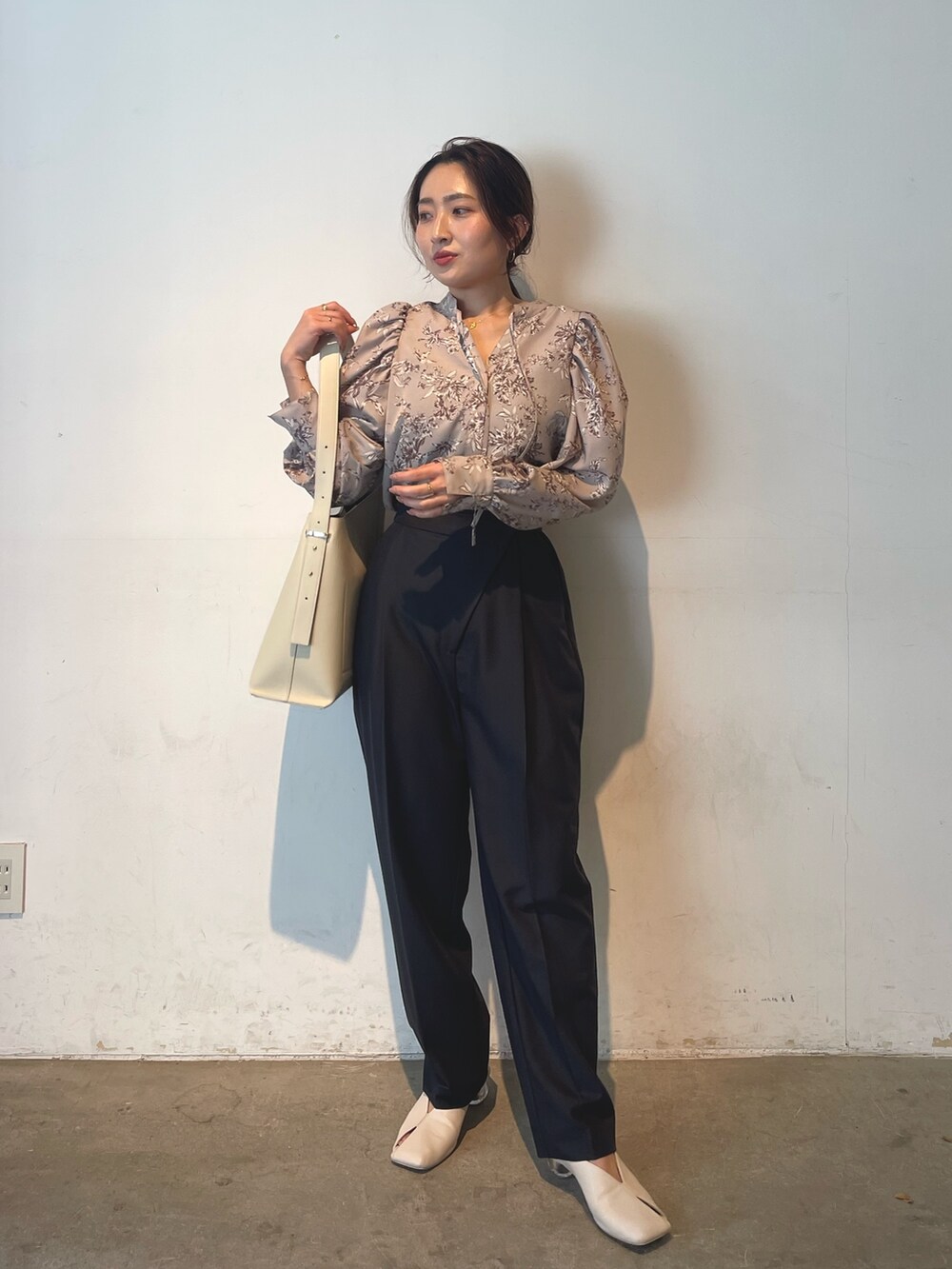 ホワイト系のショルダーバッグ、ホワイト系のパンプス、グレー系のシャツ/ブラウスを着用したレディースの冬コーディネートの6枚目の写真