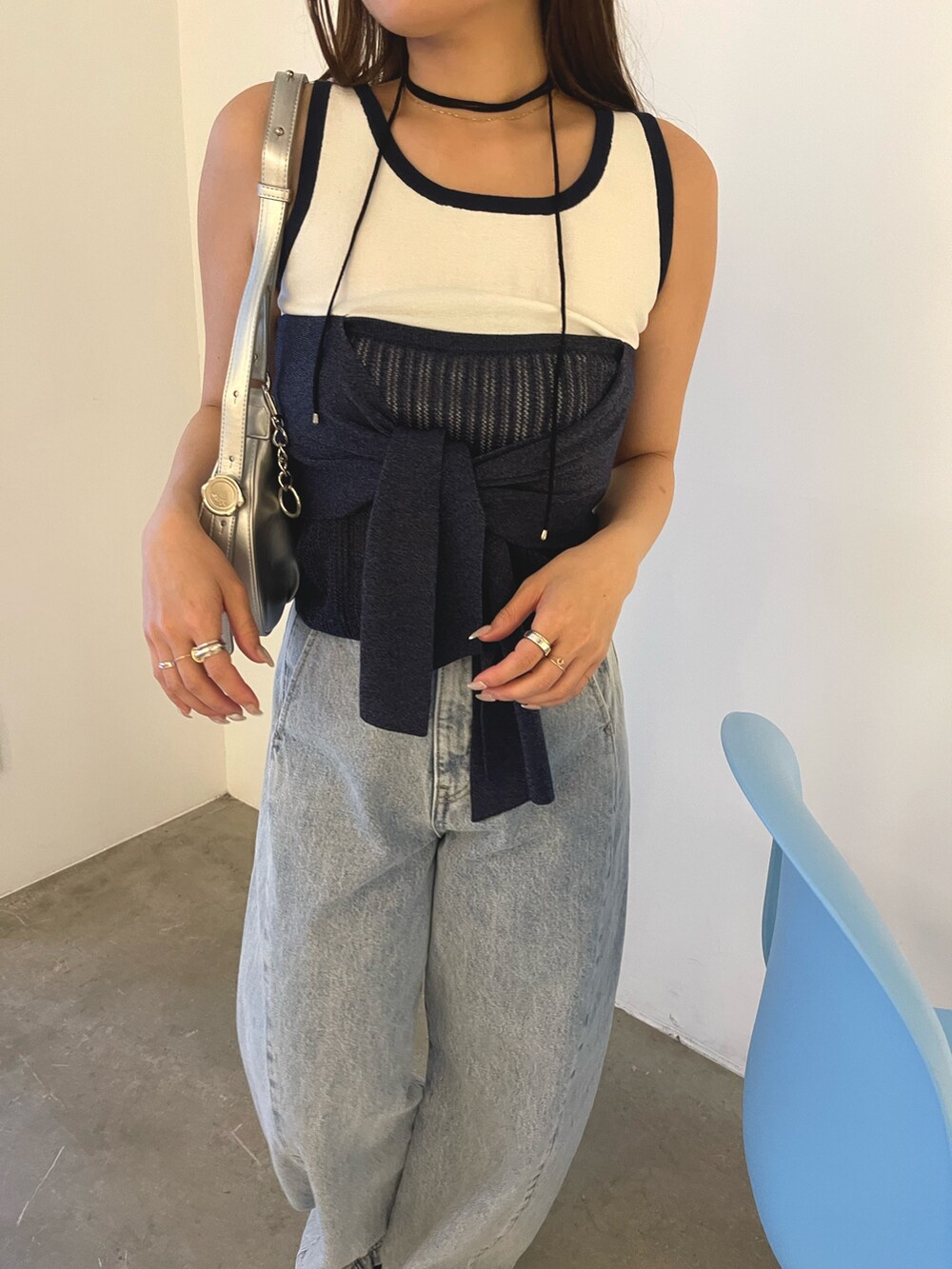 ブルー系のデニムパンツ、シルバー系のハンドバッグ、ブラウン系のサンダルを着用したレディースの春コーディネートの8枚目の写真