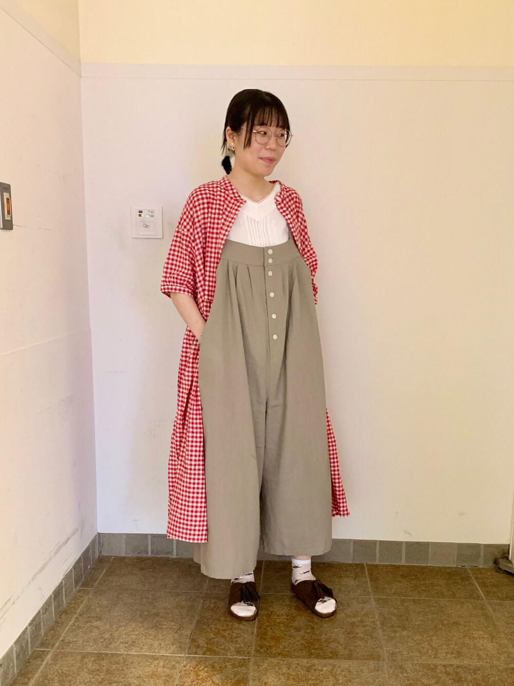ブラウン系のサンダル、グレー系のサロペット/オーバーオール、ホワイト系のTシャツ/カットソーを着用したレディースの夏コーディネートの2枚目の写真