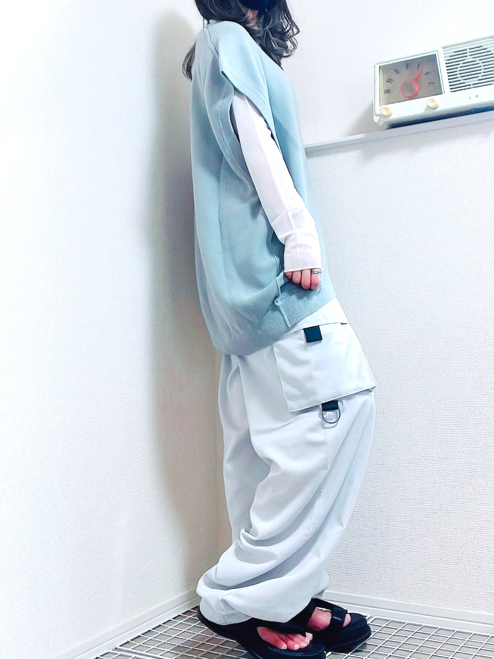 ホワイト系のトップス、ホワイト系のベスト、ブラック系のサンダルを着用したレディースの夏コーディネートの4枚目の写真