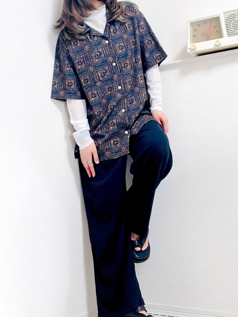 ブラック系のスラックス、ブラック系のサンダル、ホワイト系のTシャツ/カットソーを着用したレディースの夏コーディネートの2枚目の写真