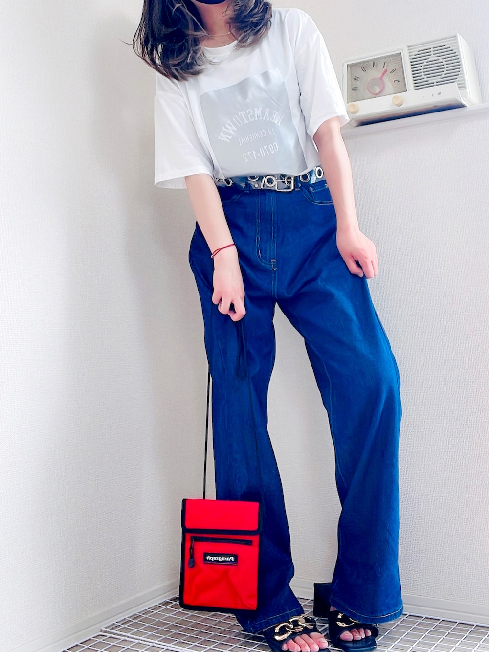 ブラック系のTシャツ/カットソー、ブルー系のデニムパンツ、レッド系のショルダーバッグを着用したレディースの夏コーディネートの2枚目の写真