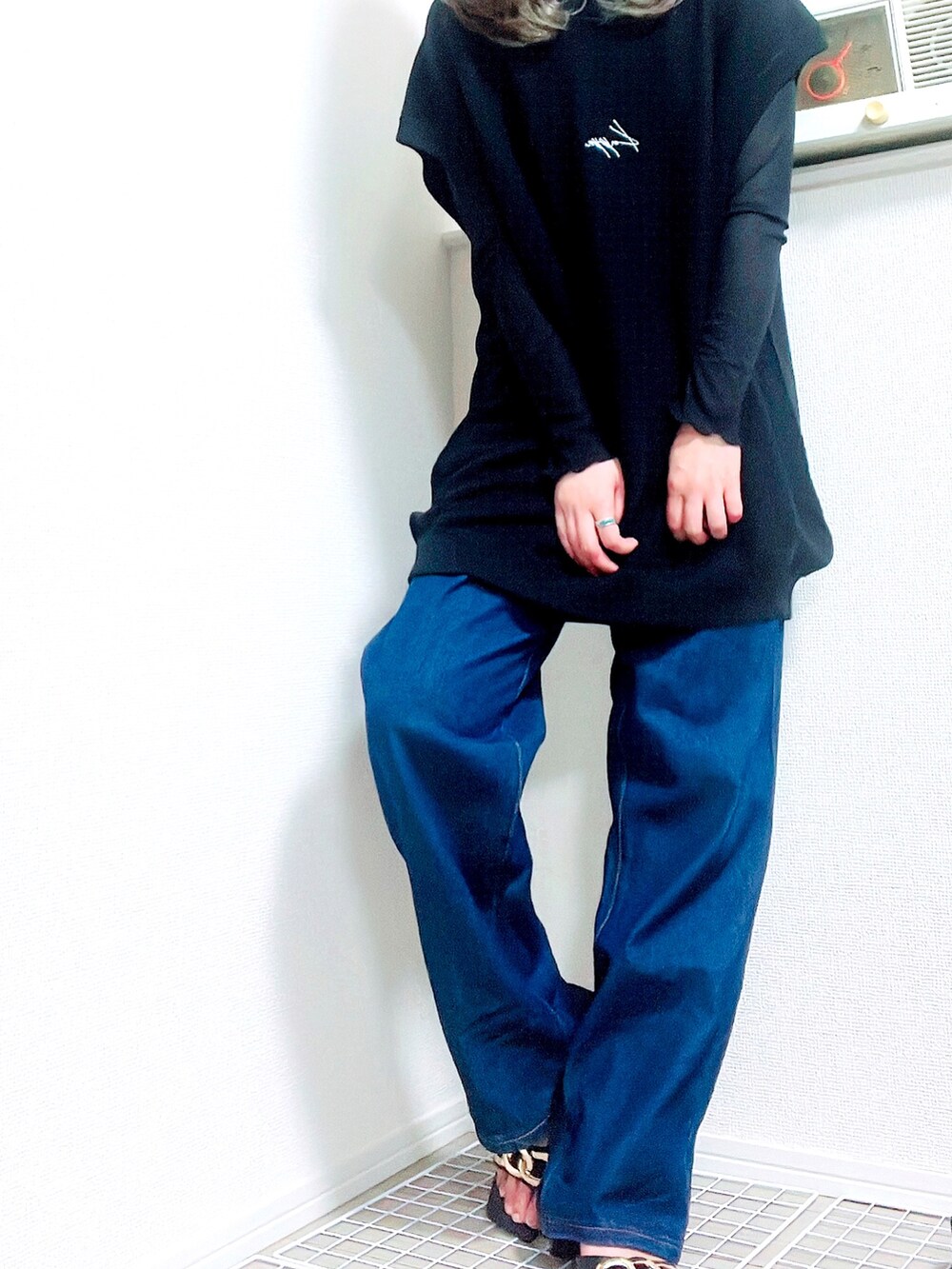 ブルー系のデニムパンツ、ホワイト系のベスト、ブラック系のその他トップスを着用したレディースの夏コーディネートの2枚目の写真